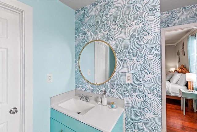 bathroom with vanity, ensuite bath, and wood finished floors