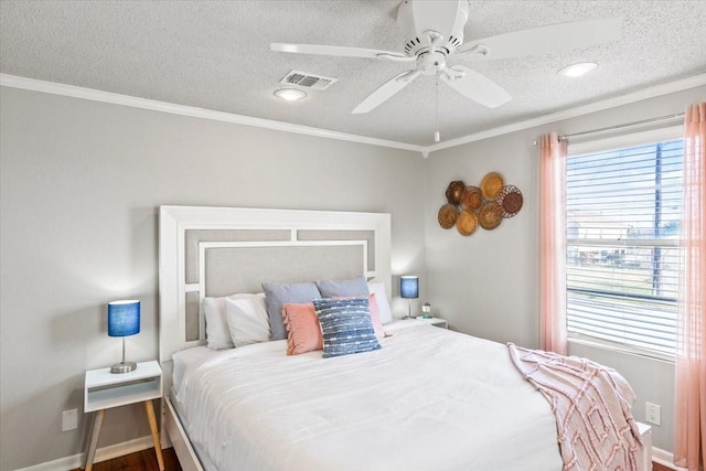 bedroom featuring a textured ceiling, baseboards, visible vents, and crown molding