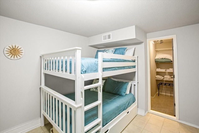 tiled bedroom with visible vents and baseboards