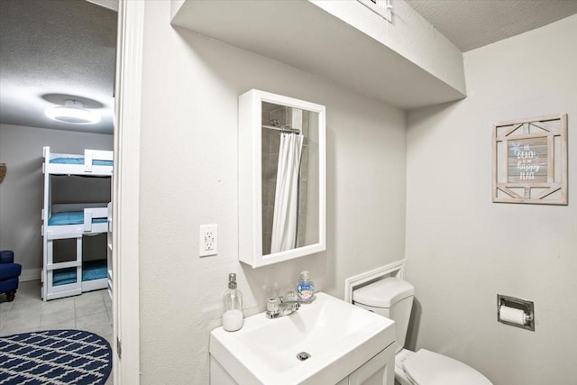 full bathroom featuring a textured ceiling, toilet, tile patterned floors, vanity, and a shower with curtain