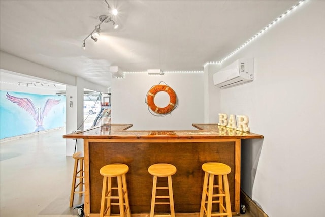 bar featuring a bar, rail lighting, and an AC wall unit