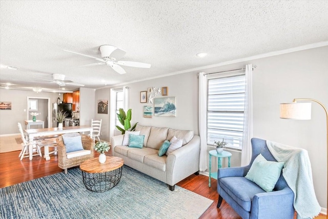 living area with plenty of natural light, crown molding, and wood finished floors