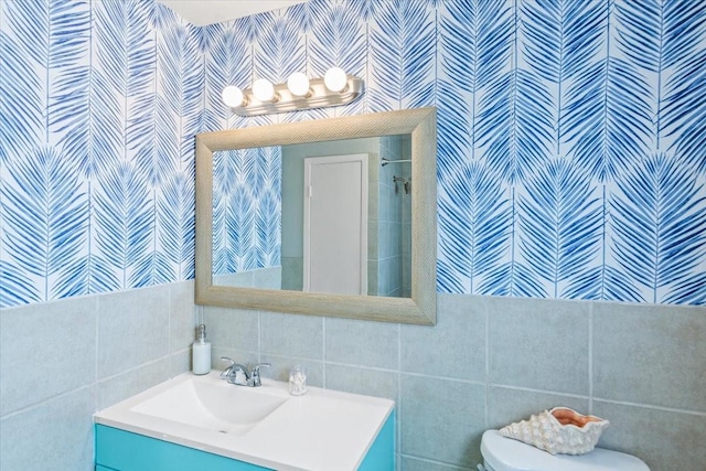 full bathroom with toilet, backsplash, tile walls, and vanity