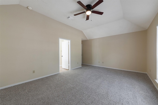 spare room featuring lofted ceiling, light colored carpet, visible vents, ceiling fan, and baseboards