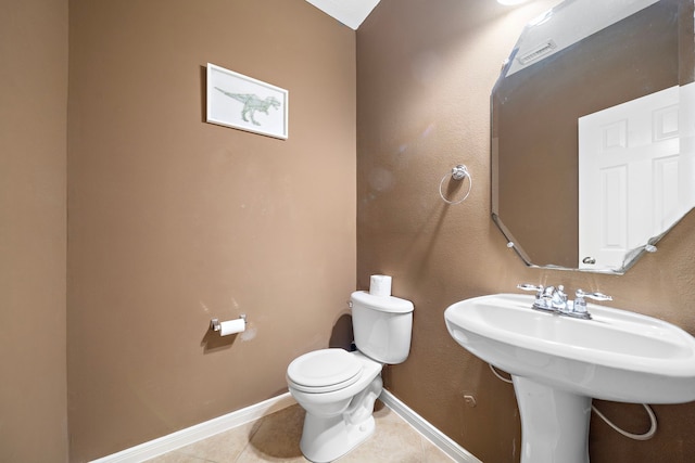 bathroom featuring toilet, tile patterned flooring, and baseboards