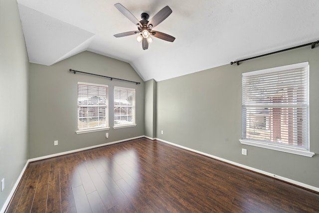 spare room with lofted ceiling, a healthy amount of sunlight, baseboards, and wood finished floors