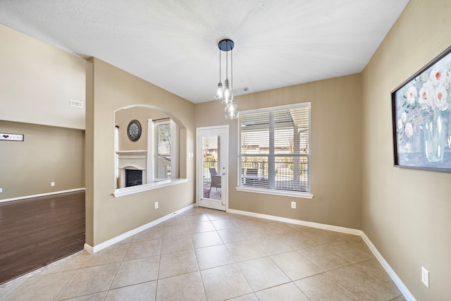 interior space with visible vents, a fireplace, baseboards, and light tile patterned flooring