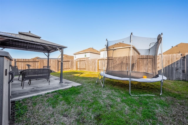 view of yard with a gazebo, a fenced backyard, a trampoline, and a patio