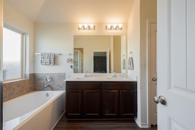 full bath featuring double vanity, a stall shower, a sink, and a bath