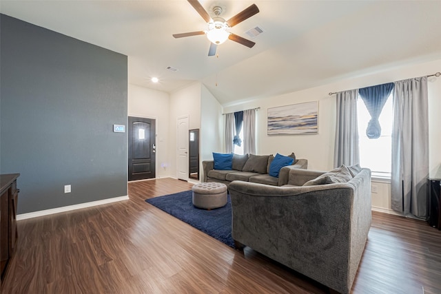 living room with lofted ceiling, ceiling fan, dark wood-type flooring, visible vents, and baseboards