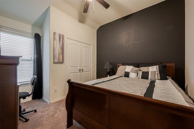 bedroom featuring lofted ceiling, carpet flooring, a ceiling fan, baseboards, and a closet