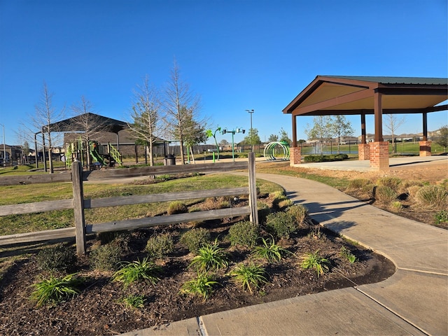 view of home's community featuring playground community and fence