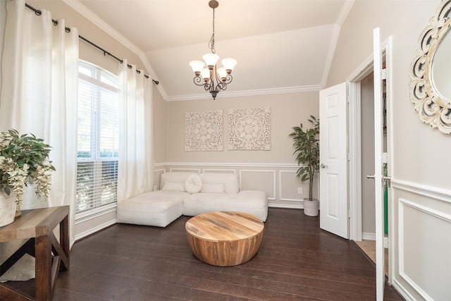 living area with vaulted ceiling, ornamental molding, wood finished floors, and a decorative wall