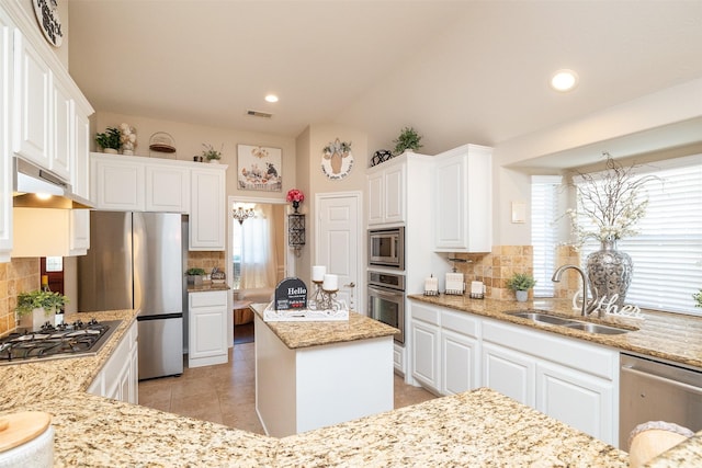 kitchen featuring appliances with stainless steel finishes, a sink, white cabinetry, and under cabinet range hood