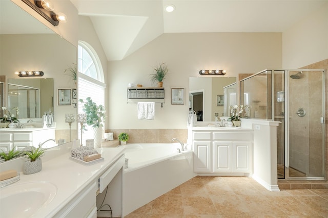 full bath with a stall shower, two vanities, vaulted ceiling, and a bath