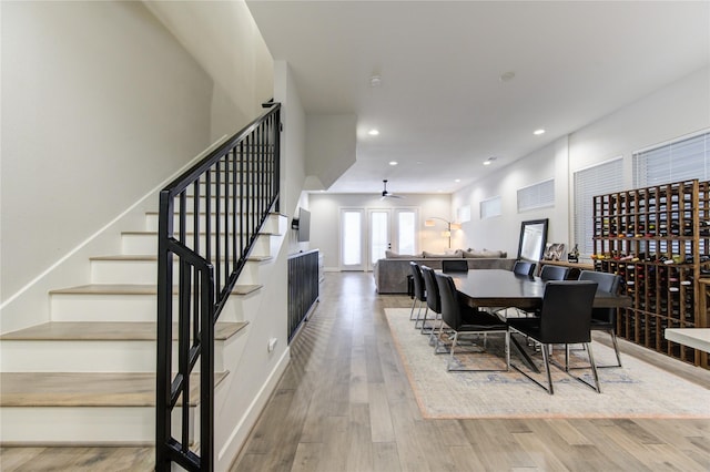 dining room with ceiling fan, recessed lighting, wood finished floors, baseboards, and stairs