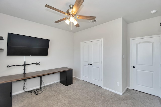 office area featuring visible vents, carpet flooring, a ceiling fan, and baseboards