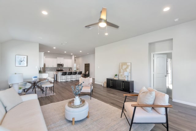 living room featuring baseboards, wood finished floors, visible vents, and recessed lighting