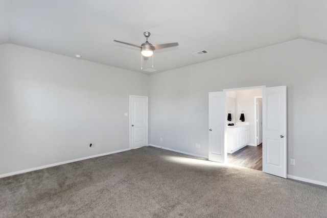 unfurnished room featuring carpet, visible vents, vaulted ceiling, ceiling fan, and baseboards