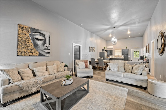 living area with a chandelier and light wood-style flooring