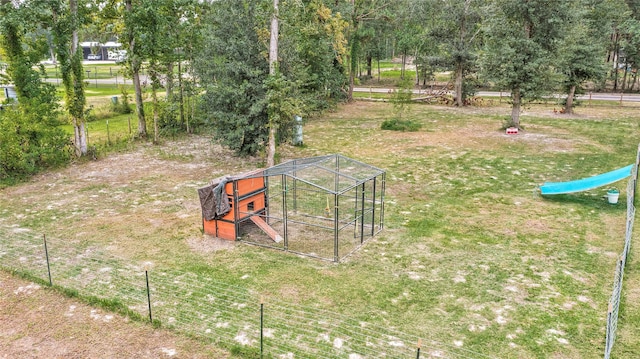 view of yard featuring an outbuilding, fence, and exterior structure