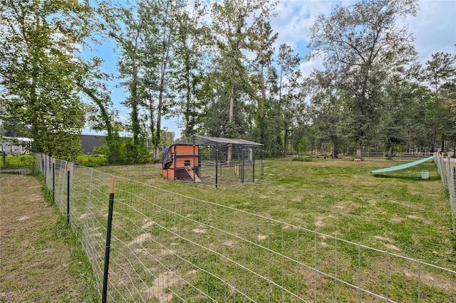 view of yard with an outdoor structure, fence, and exterior structure