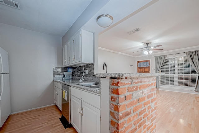 kitchen with light wood finished floors, visible vents, decorative backsplash, and dishwasher