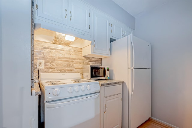 kitchen with white appliances, white cabinetry, and under cabinet range hood