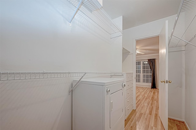 walk in closet featuring light wood-style floors and washing machine and clothes dryer