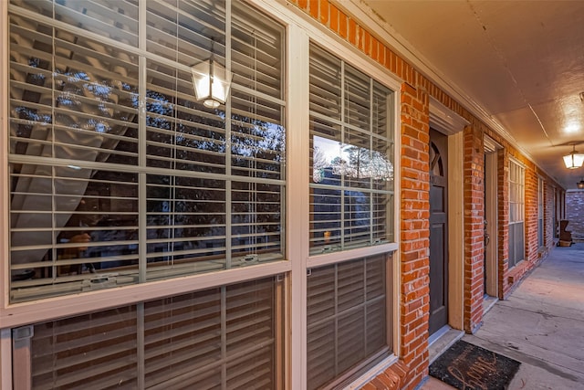 entrance to property featuring covered porch and brick siding