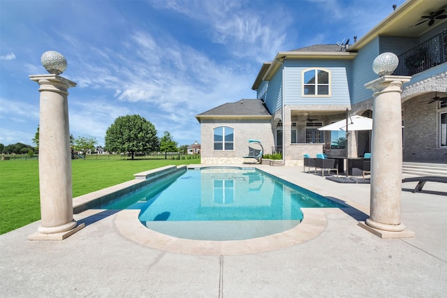 pool with a ceiling fan, a yard, and a patio