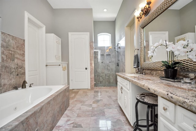 bathroom with a garden tub, a shower stall, marble finish floor, and vanity