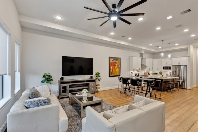 living area featuring light wood-type flooring, visible vents, ceiling fan, and recessed lighting