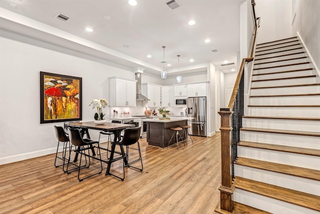 dining area featuring stairway, visible vents, light wood-style floors, and recessed lighting