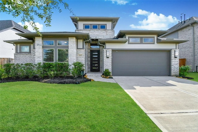 prairie-style house featuring a garage, concrete driveway, brick siding, and a front lawn