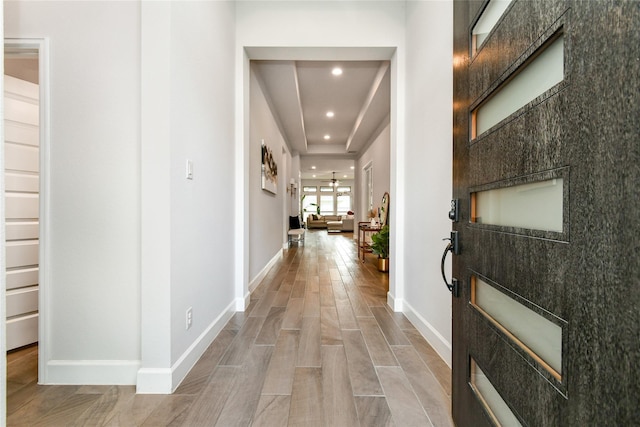 hallway with wood tiled floor, baseboards, and recessed lighting