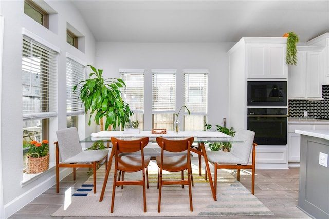 dining room featuring light wood-type flooring and baseboards