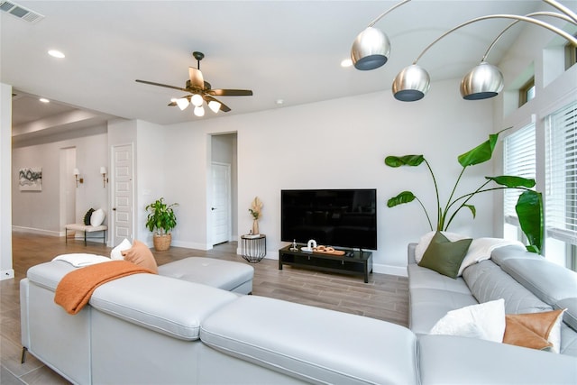 living area with baseboards, wood finished floors, visible vents, and recessed lighting