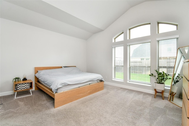 carpeted bedroom with vaulted ceiling and baseboards