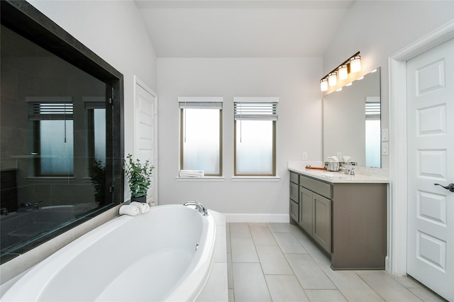 bathroom with baseboards, a garden tub, vanity, and tile patterned floors