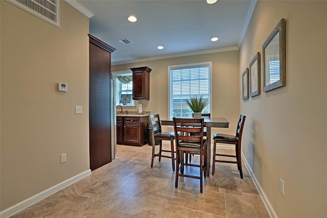 dining space featuring visible vents, crown molding, and baseboards