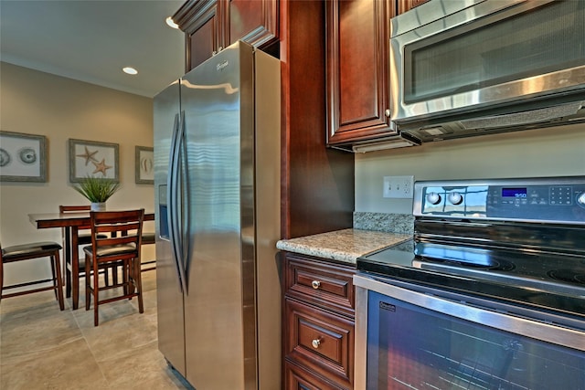 kitchen featuring stainless steel appliances, recessed lighting, and light stone counters