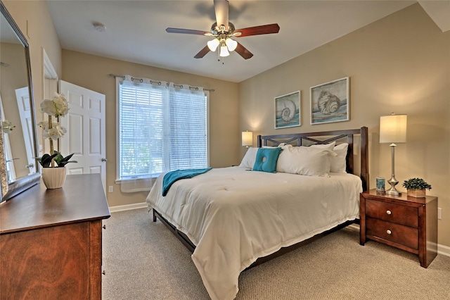 bedroom featuring a ceiling fan, light carpet, and baseboards