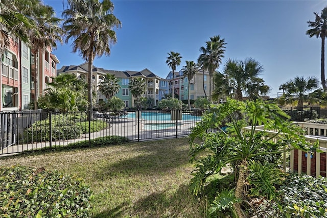 community pool with fence and a lawn