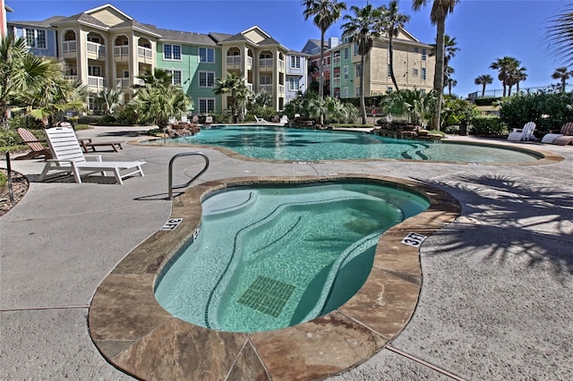 community pool featuring a hot tub and a patio