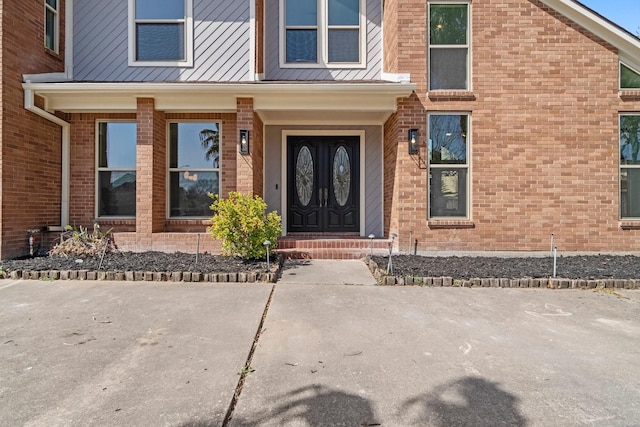 doorway to property featuring brick siding