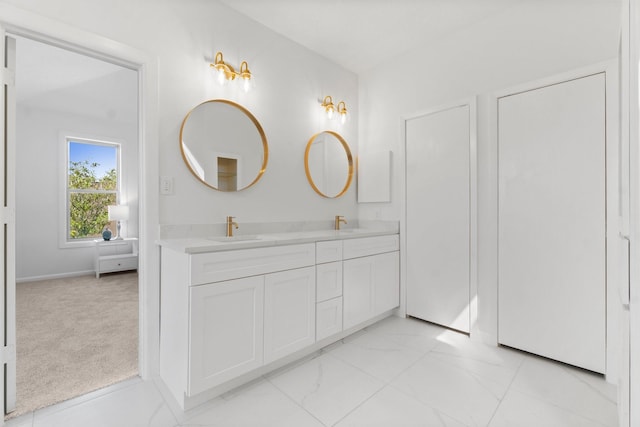 full bathroom with double vanity, marble finish floor, and a sink