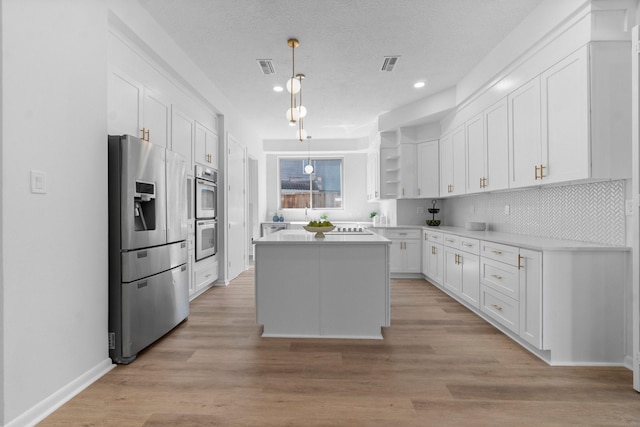 kitchen featuring open shelves, stainless steel appliances, visible vents, and white cabinetry