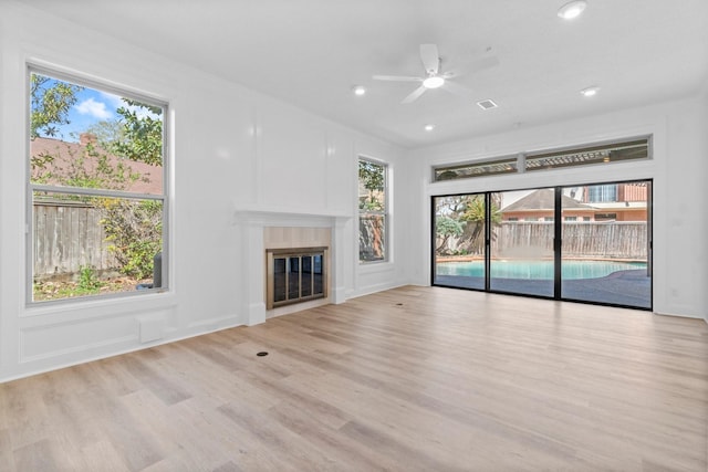 unfurnished living room featuring visible vents, a glass covered fireplace, wood finished floors, recessed lighting, and ceiling fan