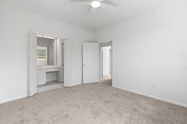 unfurnished bedroom featuring light carpet and baseboards